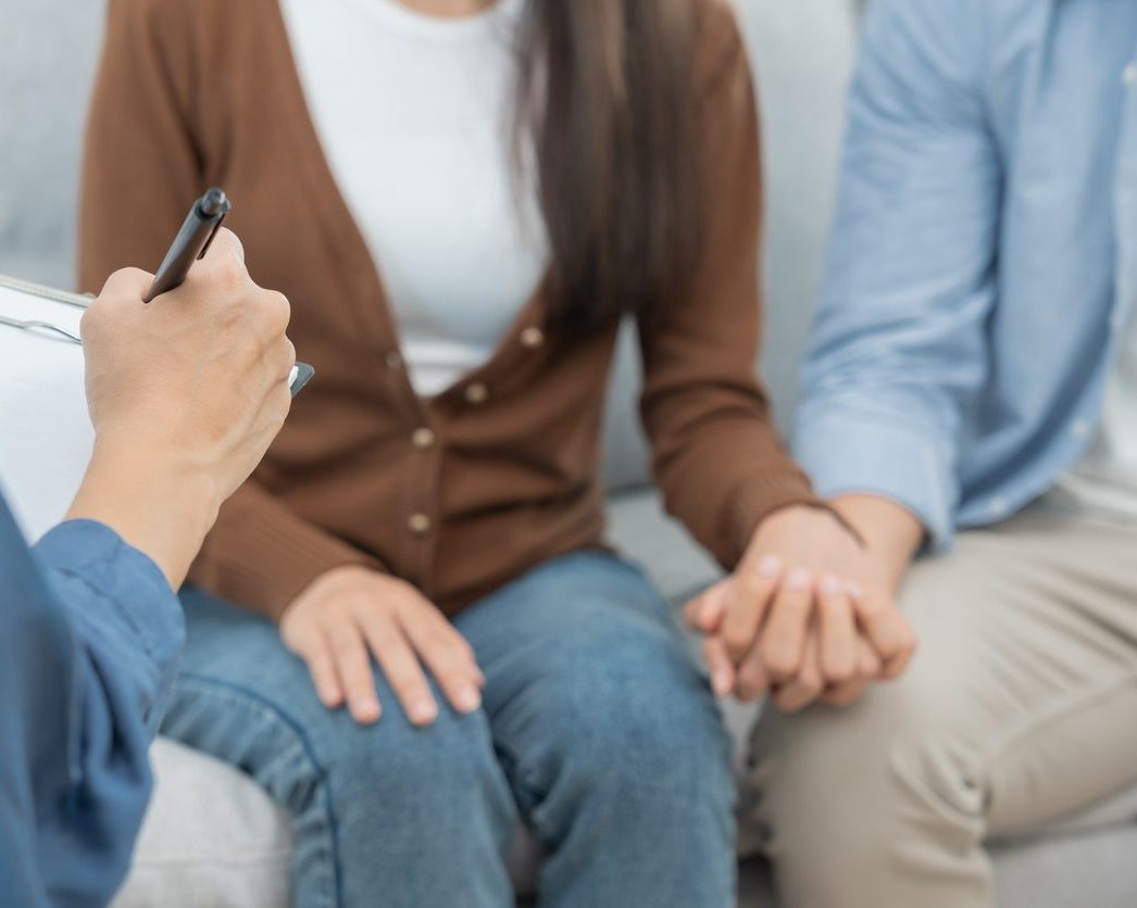 Mentaltraining für Paare. Das Paar sitzt und sie halten ihre Händchen.